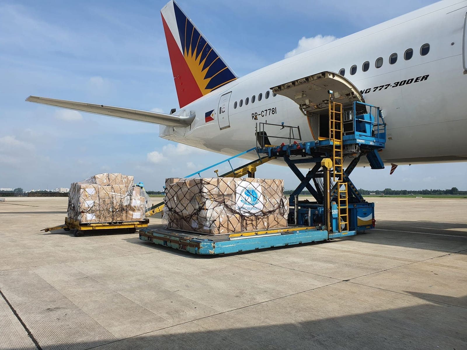 Air cargo pallets on a loader being lifted into a widebody freighter