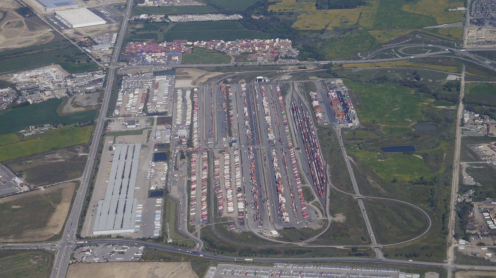 Aerial view of a large rail intermodal terminal with rows of containers