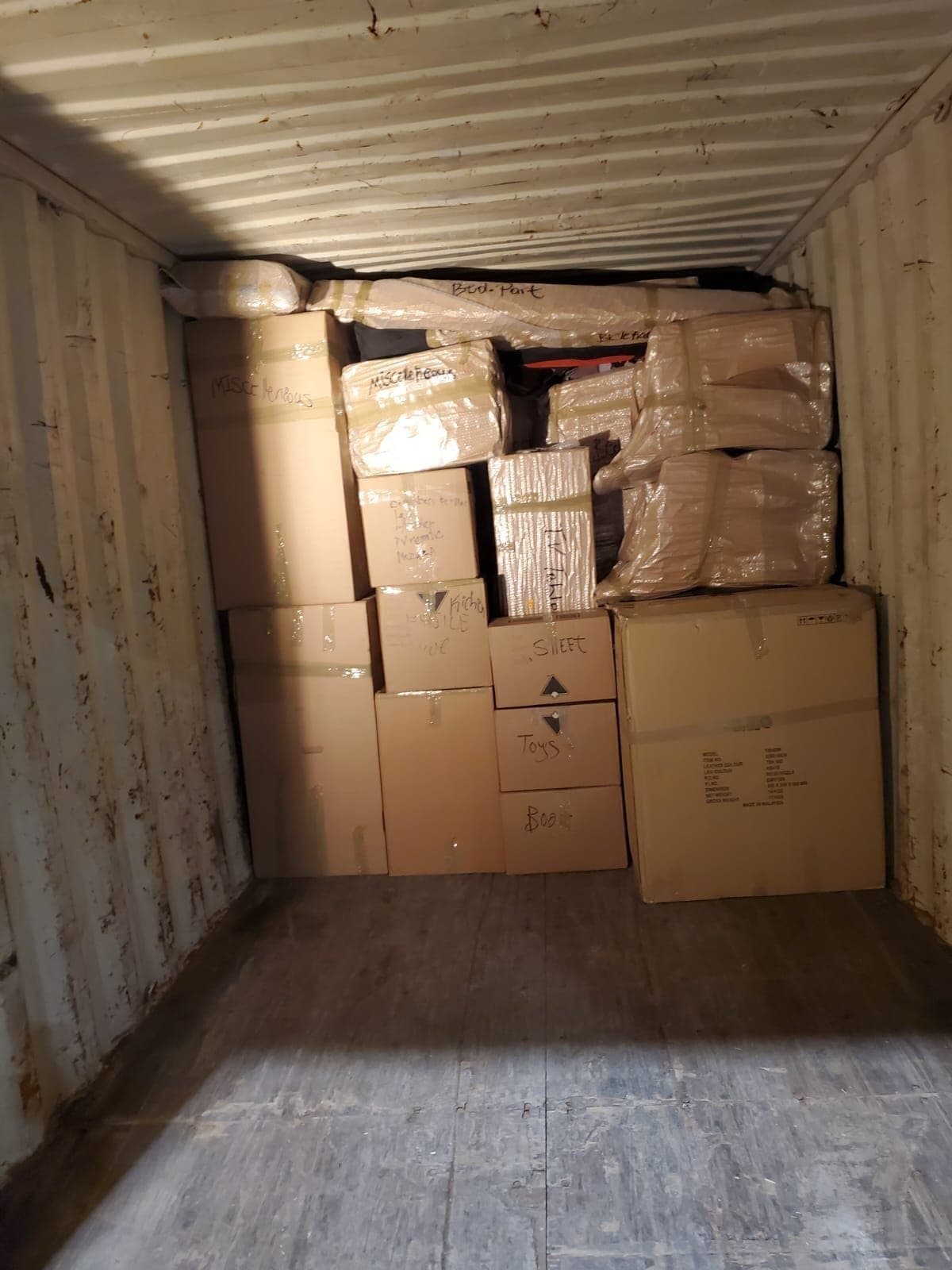 Floor-loaded container packed with labelled cartons, ready for a lumper crew to unload