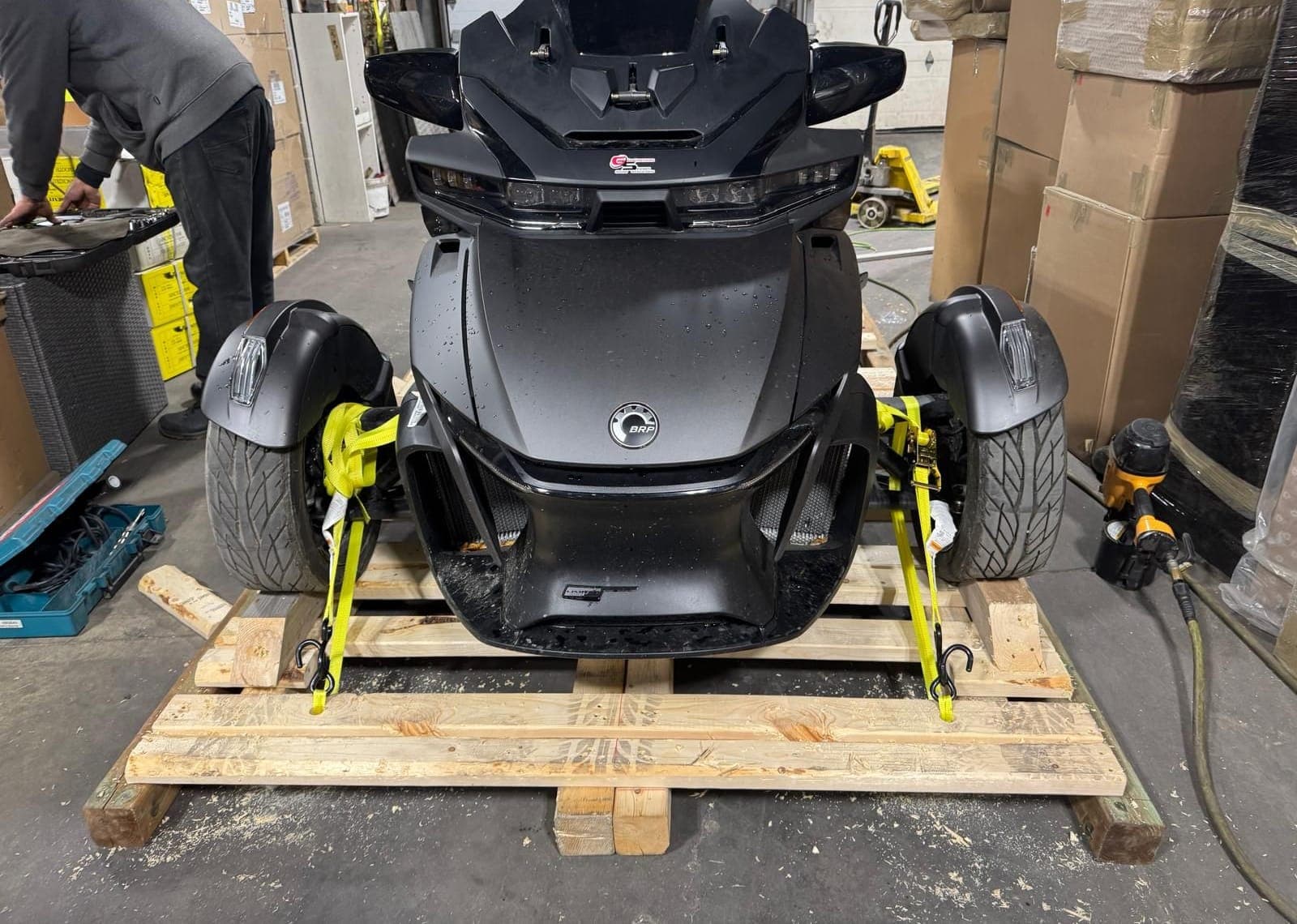 Can-Am Spyder ratchet-strapped by its wheels to a custom timber crate base at our Toronto warehouse