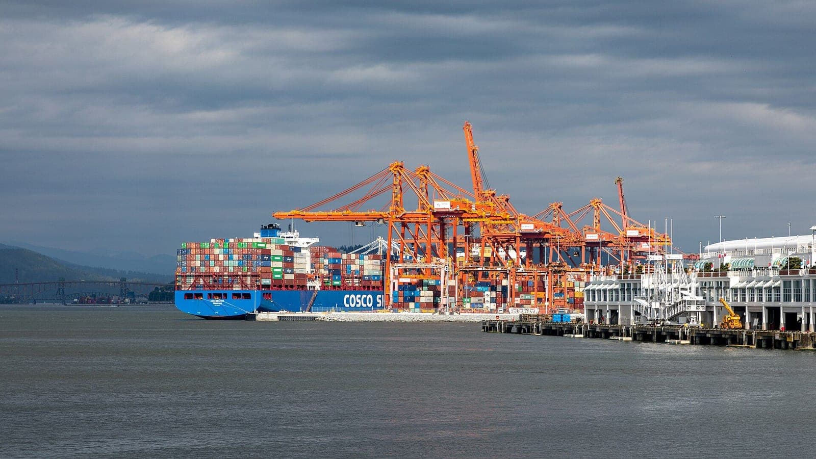 Container ship being worked under port gantry cranes