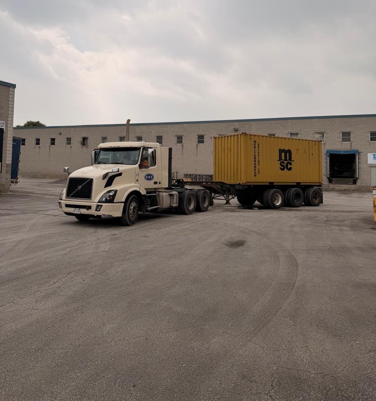 Tractor backing a 20-foot container up to the warehouse dock