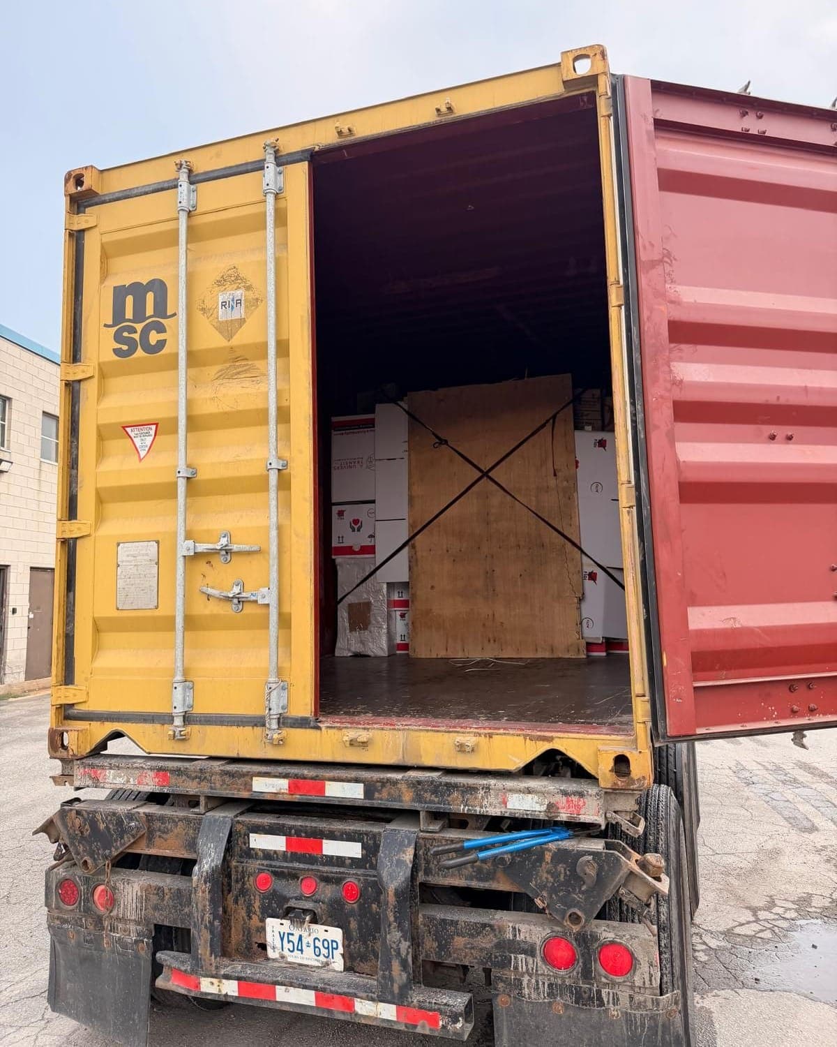 Open container at the dock with a plywood-braced export load